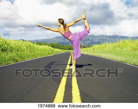Stock Photo - Hawaii, Kauai, East Side, Woman Doing Yoga On The Road.. Fotosearch