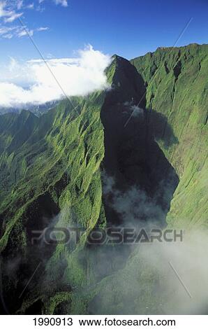 Stock Image - Hawaii, Kauai, Emerald Green Mt. Waialeale With Clouds, Fog, And Deep Ridge Shadows. Fotosearch
