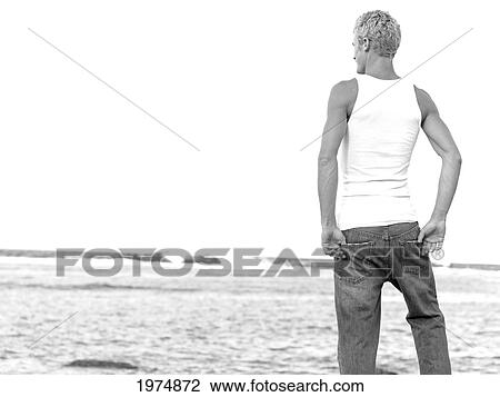 Stock Image - Hawaii, Kauai, Fit Male Posing On Rocky Coastline.. Fotosearch
