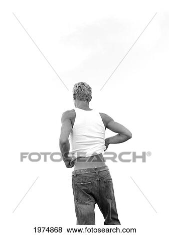 Stock Photo - Hawaii, Kauai, Fit Male Posing On Rocky Coastline.. Fotosearch