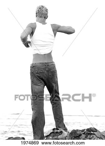 Stock Photo - Hawaii, Kauai, Fit Male Posing On Rocky Coastline.. Fotosearch