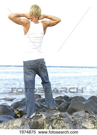 Stock Photography - Hawaii, Kauai, Fit Male Posing On Rocky Coastline.. Fotosearch