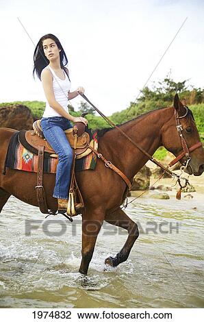 Stock Image - Hawaii, Kauai, Gillin's Beach, Beautiful Girl Riding A Horse.. Fotosearch