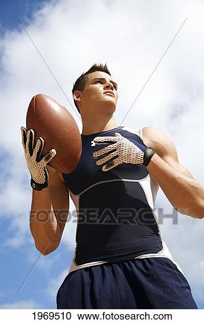 Hawaii, Kauai, Haena Beach, Fit Male Holding A Football With Beautiful Clouds In The Background. View Large Photo Image Stock Image - Hawaii, Kauai, Haena Beach, Fit Male Holding A Football With Beautiful Clouds In The Background.. Fotosearch