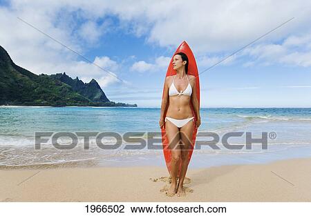 Hawaii, Kauai, Haena Beach Tunnels Beach, Woman Standing On Beach With Surfboard. View Large Photo Image Stock Image - Hawaii, Kauai, Haena Beach Tunnels Beach, Woman Standing On Beach With Surfboard.. Fotosearch