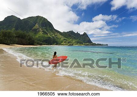 Hawaii, Kauai, Haena Beach Tunnels Beach, Woman Entering Ocean With Surfboard. View Large Photo Image Stock Photography - Hawaii, Kauai, Haena Beach Tunnels Beach, Woman Entering Ocean With Surfboard.. Fotosearch