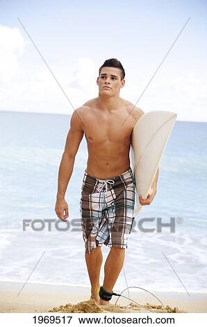 Stock Photo - Hawaii, Kauai, Haena Beach, Young Man At The Beach Walking With Surfboard.. Fotosearch