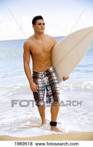Stock Photo - Hawaii, Kauai, Haena Beach, Young Man At The Beach Walking With Surfboard.. Fotosearch