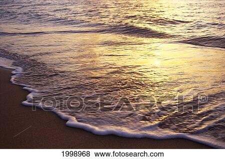 Stock Photo - Hawaii, Kauai, Haena, Sunset Reflected On Water, Washing Onto Beach, B1499. Fotosearch