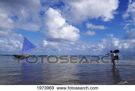Hawaii, Kauai, Hanalei Bay, Man With Paddle Wading Out Into Water To Sailing Canoe. View Large Photo Image Stock Photo - Hawaii, Kauai, Hanalei Bay, Man With Paddle Wading Out Into Water To Sailing Canoe.. Fotosearch