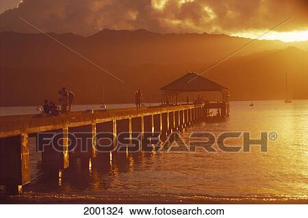 Picture - Hawaii, Kauai, Hanalei Bay, Pier With People Fishing At Sunset Golden Orange Reflections. Fotosearch