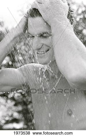 Stock Photo - Hawaii, Kauai, Hanalei Bay, Young Man At The Beach Showering After A Day Of Surfing.. Fotosearch