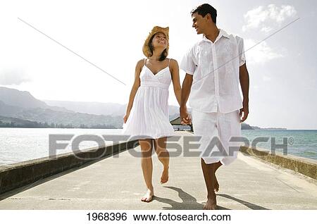 Stock Photograph - Hawaii, Kauai, Hanalei Bay, Young Couple Holding Eachother On The Pier.. Fotosearch
