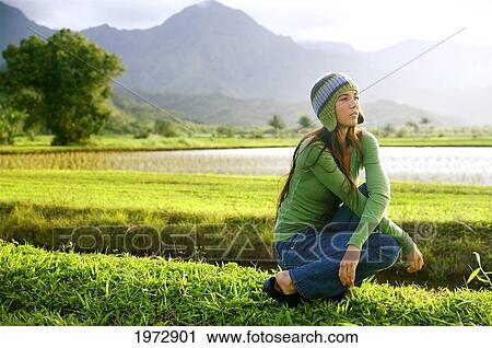 Stock Image - Hawaii, Kauai, Hanalei, Beautiful Fashion Model 0N A Grassy Field.. Fotosearch