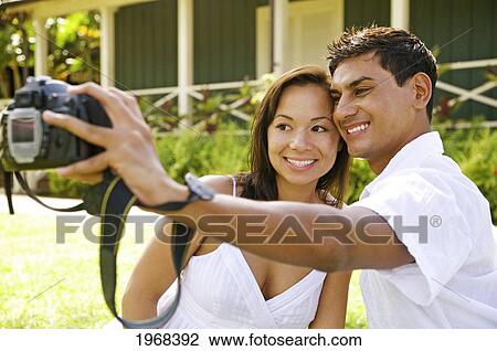 Stock Image - Hawaii, Kauai, Hanalei, Young Couple Posing For The Camera.. Fotosearch