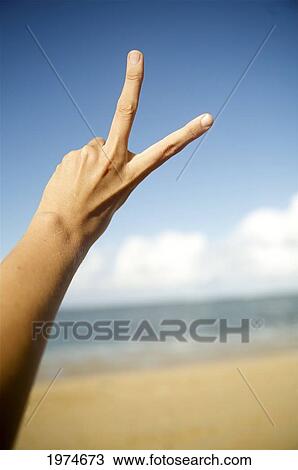 Stock Image - Hawaii, Kauai, Hand Gestures At The Beach (Peace).. Fotosearch