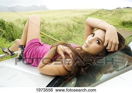 Hawaii, Kauai, Headshot Of Attractive Young Woman Wearing A Pink Dress Sitting On A Car. View Large Photo Image Stock Photograph - Hawaii, Kauai, Headshot Of Attractive Young Woman Wearing A Pink Dress Sitting On A Car.. Fotosearch