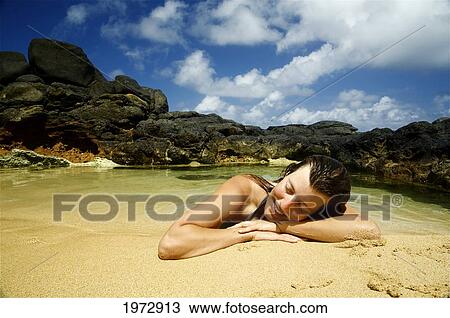 Hawaii, Kauai, Kauapea Beach (Secret Beach) Beautiful Woman Resting On The Sand. View Large Photo Image Stock Image - Hawaii, Kauai, Kauapea Beach (Secret Beach) Beautiful Woman Resting On The Sand.. Fotosearch