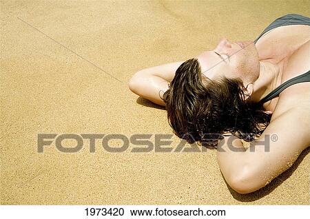 Stock Image - Hawaii, Kauai, Kauapea Beach (Secret Beach) Beautiful Woman Resting On The Sand.. Fotosearch