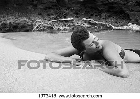 Hawaii, Kauai, Kauapea Beach (Secret Beach) Beautiful Woman Resting On The Sand, Black And White. View Large Photo Image Stock Photo - Hawaii, Kauai, Kauapea Beach (Secret Beach) Beautiful Woman Resting On The Sand, Black And White.. Fotosearch