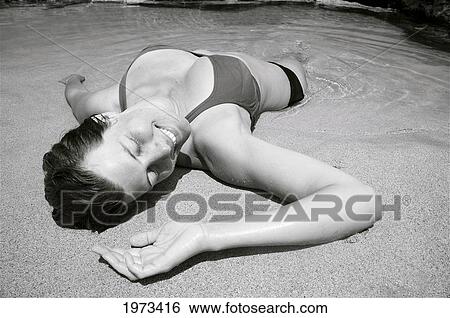 Hawaii, Kauai, Kauapea Beach (Secret Beach) Beautiful Woman Resting On The Sand, Black And White. View Large Photo Image Stock Photograph - Hawaii, Kauai, Kauapea Beach (Secret Beach) Beautiful Woman Resting On The Sand, Black And White.. Fotosearch
