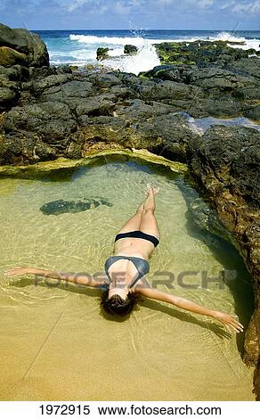 Hawaii, Kauai, Kauapea Beach (Secret Beach) Beautiful Woman Foating In The Water. View Large Photo Image Stock Photography - Hawaii, Kauai, Kauapea Beach (Secret Beach) Beautiful Woman Foating In The Water.. Fotosearch