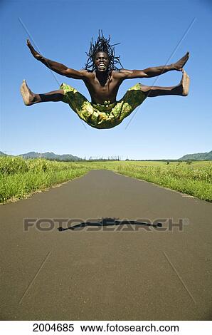Hawaii, Kauai, Kealia, African Dancer Leaping Into The Air On Country Road. View Large Photo Image Stock Photography - Hawaii, Kauai, Kealia, African Dancer Leaping Into The Air On Country Road.. Fotosearch
