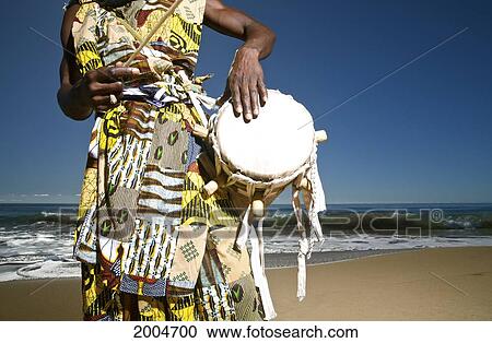 Stock Image - Hawaii, Kauai, Kealia Beach, African Dancer With Drum On Shore.. Fotosearch