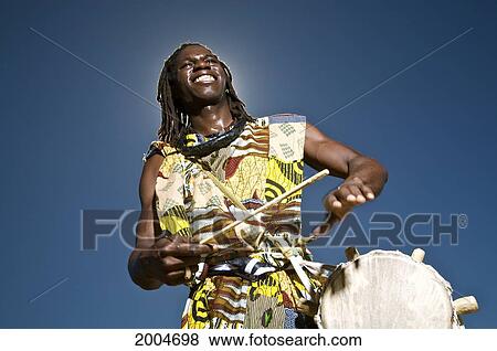 Stock Photo - Hawaii, Kauai, Kealia Beach, African Dancer With Drum, Blue Sky.. Fotosearch