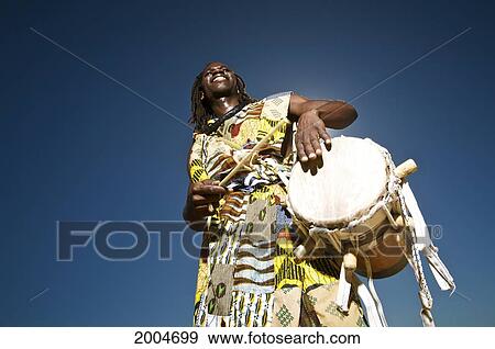 Stock Photo - Hawaii, Kauai, Kealia Beach, African Dancer With Drum, Angled View From Below.. Fotosearch