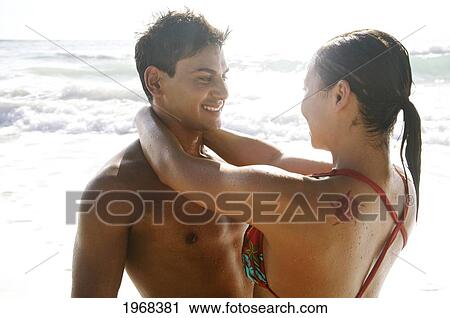 Stock Image - Hawaii, Kauai, Kealia Beach, Beautiful Couple On The Beach Having Fun.. Fotosearch