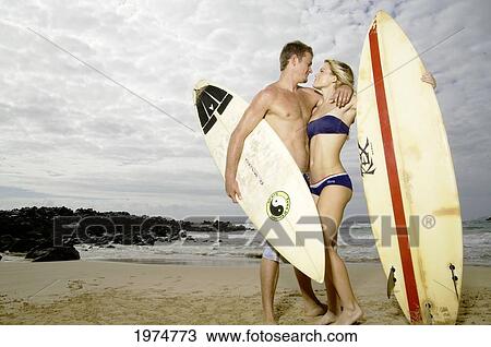 Stock Image - Hawaii, Kauai, Kealia Beach, Beautiful Surfer Couple On The Beach.. Fotosearch