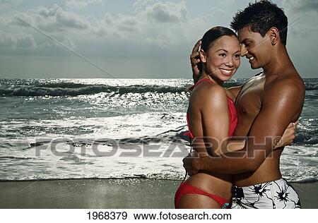 Stock Photo - Hawaii, Kauai, Kealia Beach, Beautiful Couple On The Beach Having Fun.. Fotosearch
