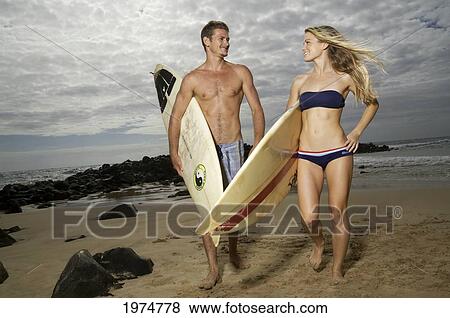 Stock Photo - Hawaii, Kauai, Kealia Beach, Beautiful Surfer Couple On The Beach.. Fotosearch