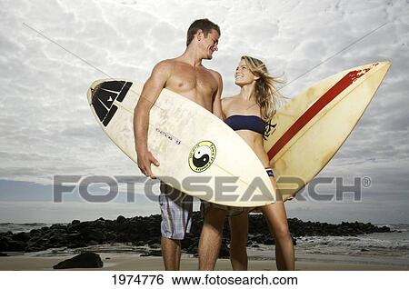 Stock Photograph - Hawaii, Kauai, Kealia Beach, Beautiful Surfer Couple On The Beach.. Fotosearch