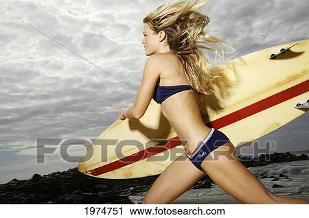 Stock Image - Hawaii, Kauai, Kealia Beach, Surfer Girl Enjoying A Day Out.. Fotosearch