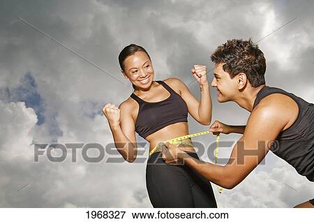 Hawaii, Kauai, Kealia Beach, Young Fit Couple Doing Body Measurements. View Large Photo Image Stock Photo - Hawaii, Kauai, Kealia Beach, Young Fit Couple Doing Body Measurements.. Fotosearch