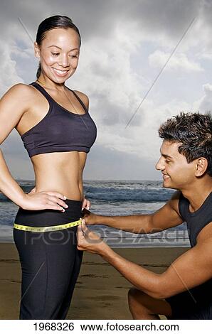 Hawaii, Kauai, Kealia Beach, Young Fit Couple Doing Body Measurements. View Large Photo Image Stock Photograph - Hawaii, Kauai, Kealia Beach, Young Fit Couple Doing Body Measurements.. Fotosearch
