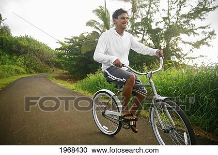 Hawaii, Kauai, Kealia Beach, Young Man Riding A Bike On The Bike Path. View Large Photo Image Stock Image - Hawaii, Kauai, Kealia Beach, Young Man Riding A Bike On The Bike Path.. Fotosearch