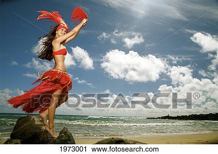 Stock Image - Hawaii, Kauai, Kealia, Beautiful Hawaiian Girl Dancing Hula On Ocean Shoreline.. Fotosearch