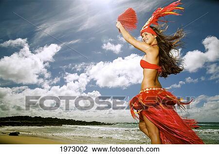 Stock Image - Hawaii, Kauai, Kealia, Beautiful Hawaiian Girl Dancing Hula On Ocean Shoreline.. Fotosearch