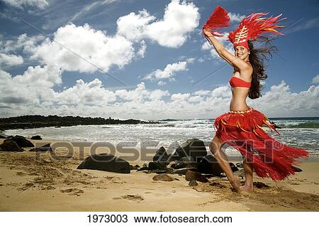Stock Image - Hawaii, Kauai, Kealia, Beautiful Hawaiian Girl Dancing Hula On Ocean Shoreline.. Fotosearch