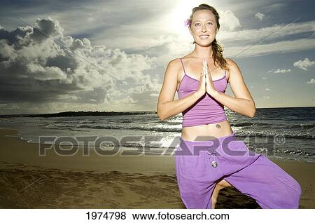 Stock Photo - Hawaii, Kauai, Kealia, Woman Doing Yoga.. Fotosearch