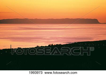 Stock Image - Hawaii, Kauai, Kekaha, Over-View Of Coast At Twilight, Niihau In Distance, Orange Sky. Fotosearch