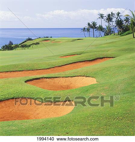 Stock Image - Hawaii, Kauai, Lihue, Kauai Lagoons Golf Course, Kiele Course, Large Sandtrap, Palm Trees And Ocean.. Fotosearch