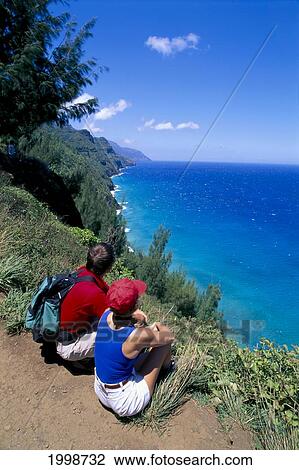 Hawaii, Kauai, Na Pali Coast, Couple Hikers On Trail View From Behind, Overlook Ocean View Large Photo Image Stock Image - Hawaii, Kauai, Na Pali Coast, Couple Hikers On Trail View From Behind, Overlook Ocean. Fotosearch