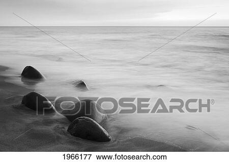 Stock Photo - Hawaii, Kauai, Na Pali Coast, Evening Light Over Kalalau Beach, Long Exposure On Ocean And Rocks, Black And White Photograph.. Fotosearch