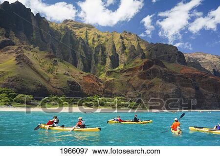 Stock Photo - Hawaii, Kauai, Na Pali Coast, Group Of Kayakers Paddling Along Coastline, Beautiful Mountain Ridges In Background. Editorial Use Only.. Fotosearch