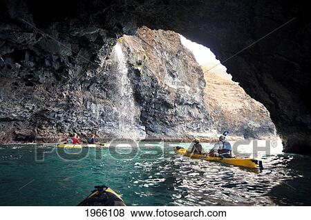 Hawaii, Kauai, Na Pali Coast, Group Of Kayakers Exploring Sea Cave Along Coastline, Waterfall From Cliffside. Editorial Use Only. View Large Photo Image Stock Photo - Hawaii, Kauai, Na Pali Coast, Group Of Kayakers Exploring Sea Cave Along Coastline, Waterfall From Cliffside. Editorial Use Only.. Fotosearch
