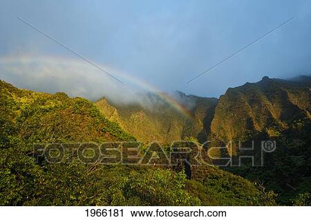 Stock Image - Hawaii, Kauai, Na Pali Coast, Rainbow Over Hanakoa Valley In The Evening.. Fotosearch